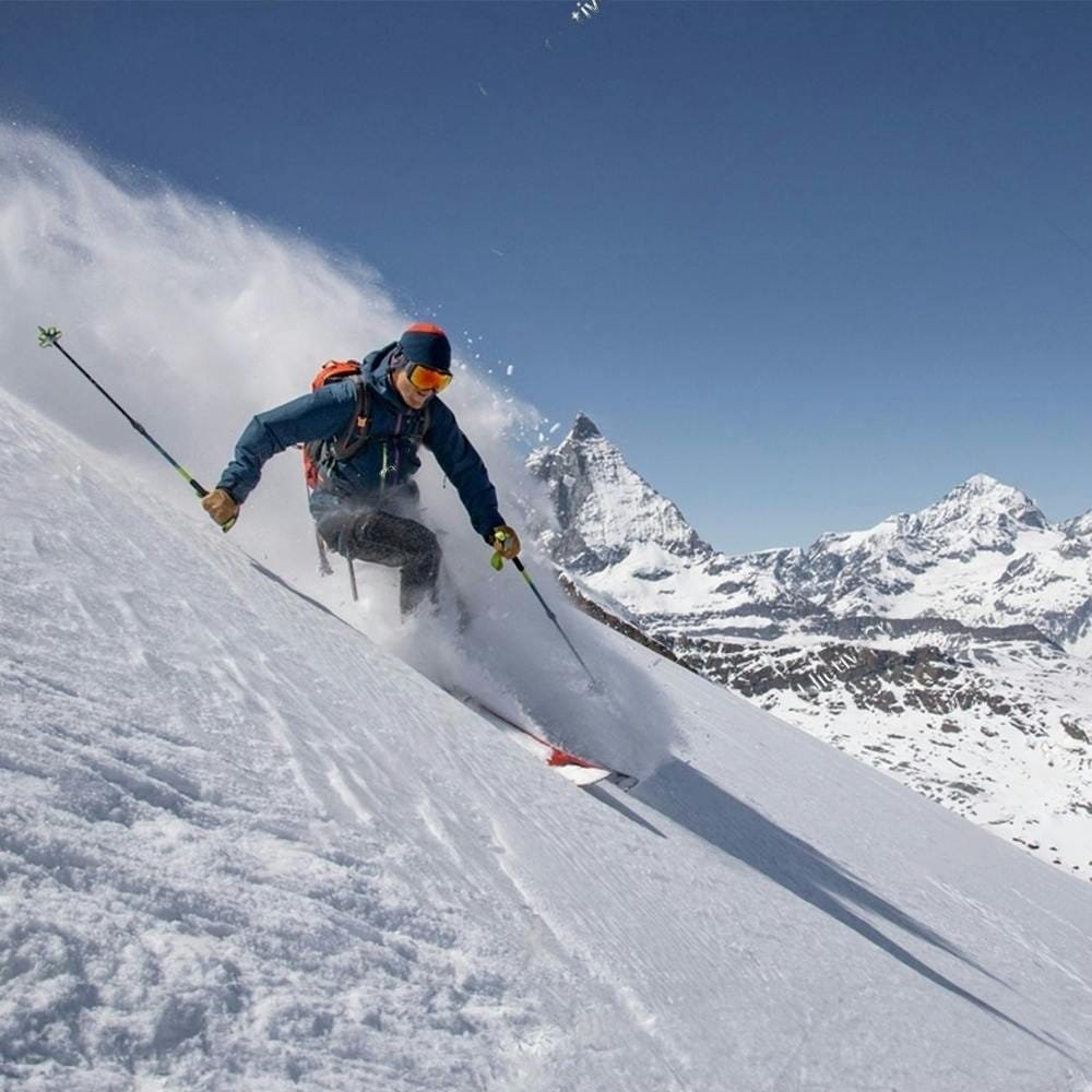 Skier making a turn in a snowy mountain landscape